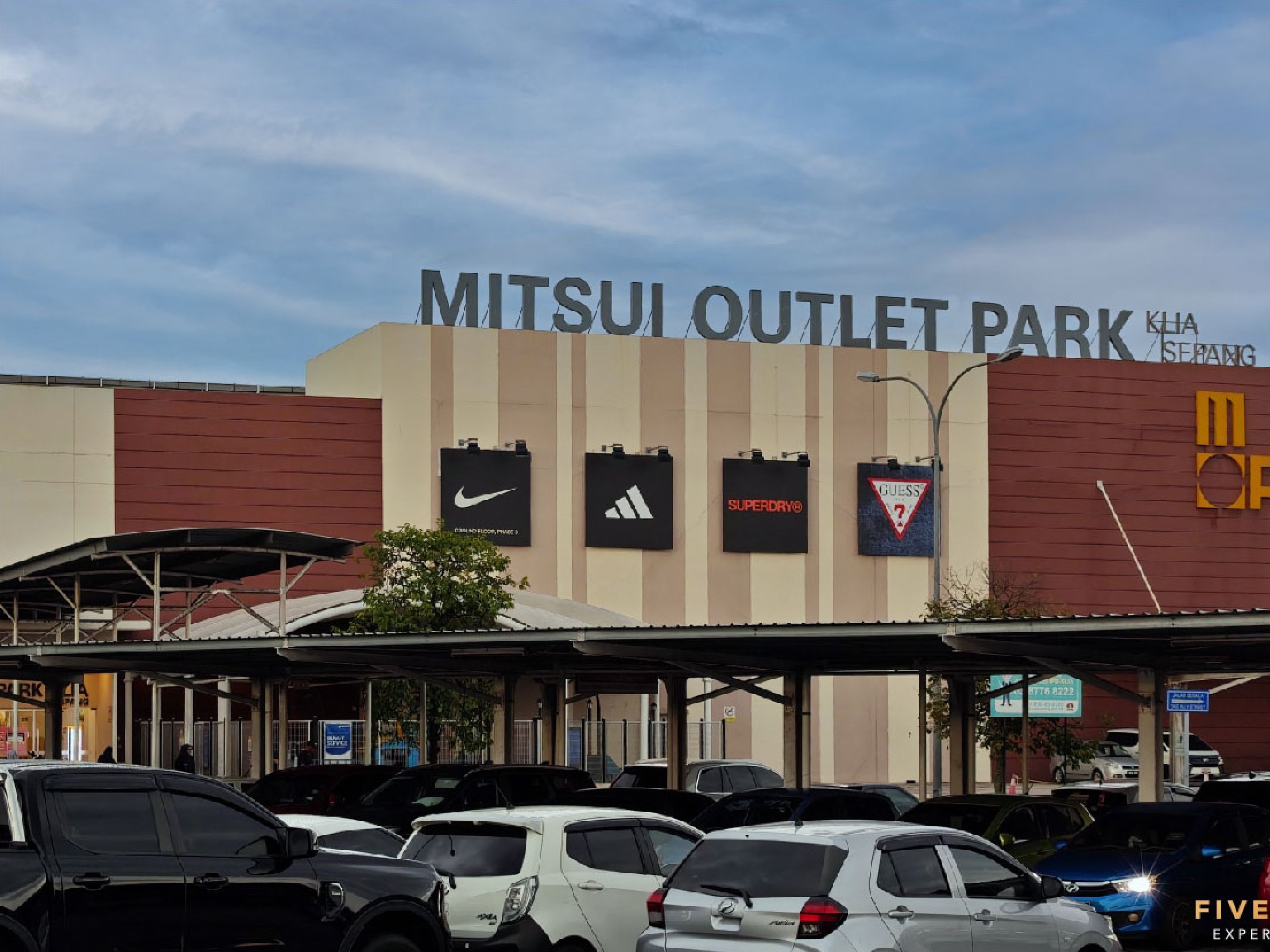A parking area with cars and a building labeled "MITSUI OUTLET PARK."