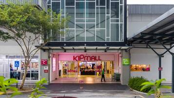 En KIPMALL butik med en moderne glasfacade, en lågeindgang og et synligt skilt for handicapparkering.