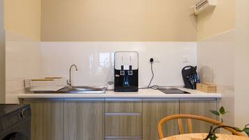 A modern kitchen with a coffee maker, a toaster, and a sink.