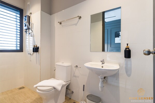 Et moderne badeværelse med toilet, håndvask og brusebad.
