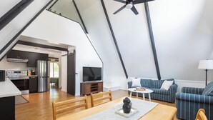 A modern loft with a kitchen, dining area, and living room.