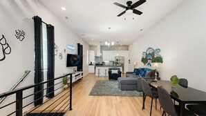 Eine moderne Wohnung mit Wohnzimmer, Essbereich, Küche und Treppe.