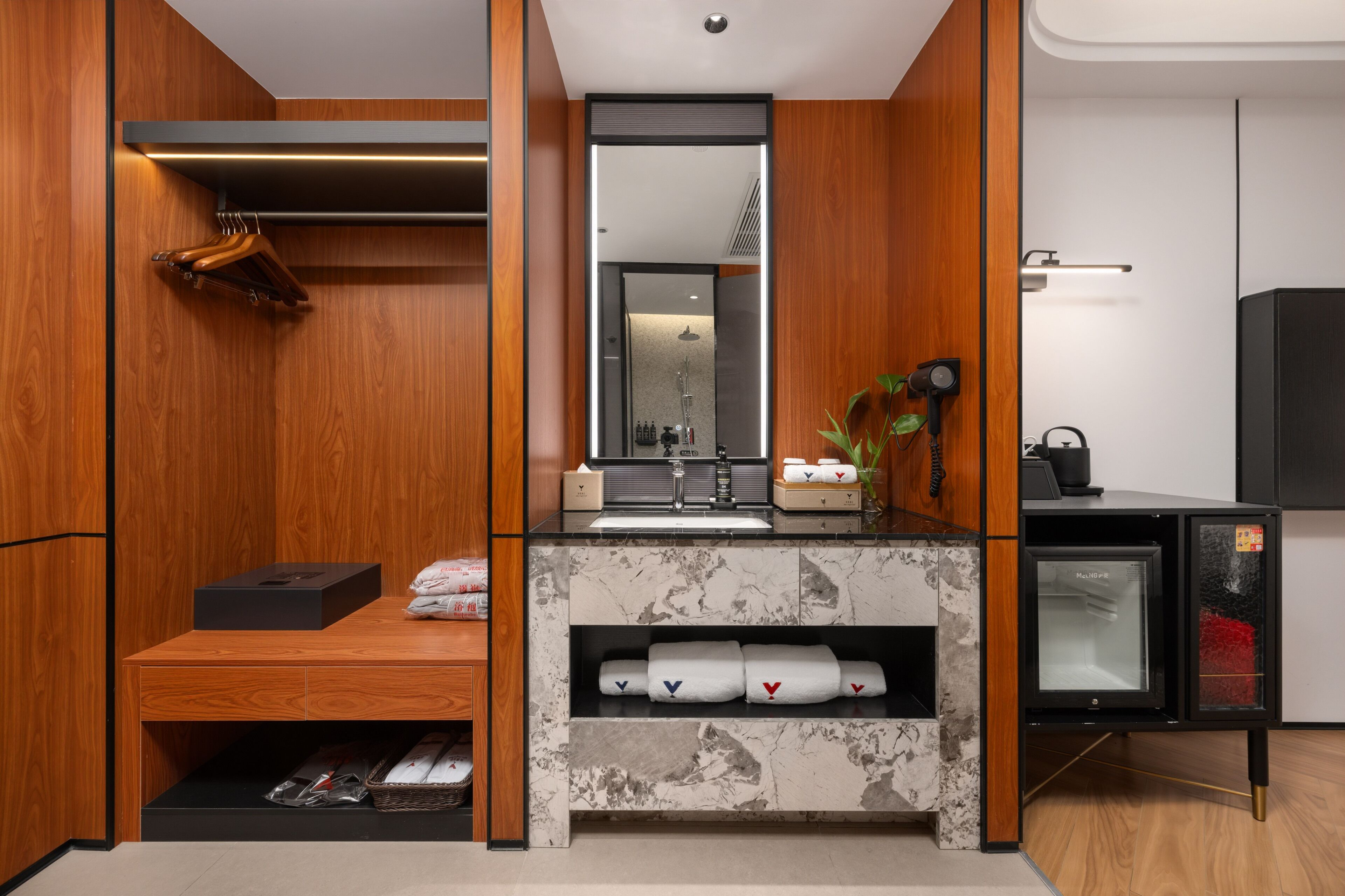 A modern bathroom with a wooden vanity, a mirror, a sink, and a built-in refrigerator.