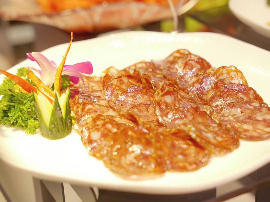 A plate of food with sliced meat and garnishes.