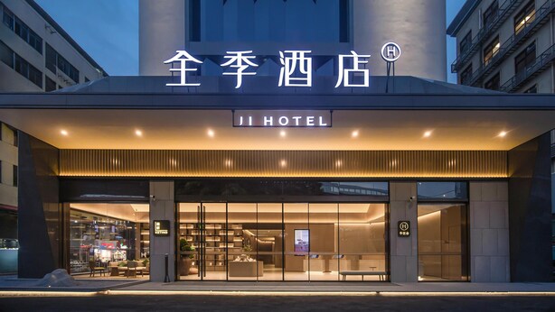 A hotel entrance with a modern design, featuring a prominent sign and a reception area with seating. - Ji Hotel Guangzhou Baiyun Station Sanyuanli Avenue (Guangzhou)