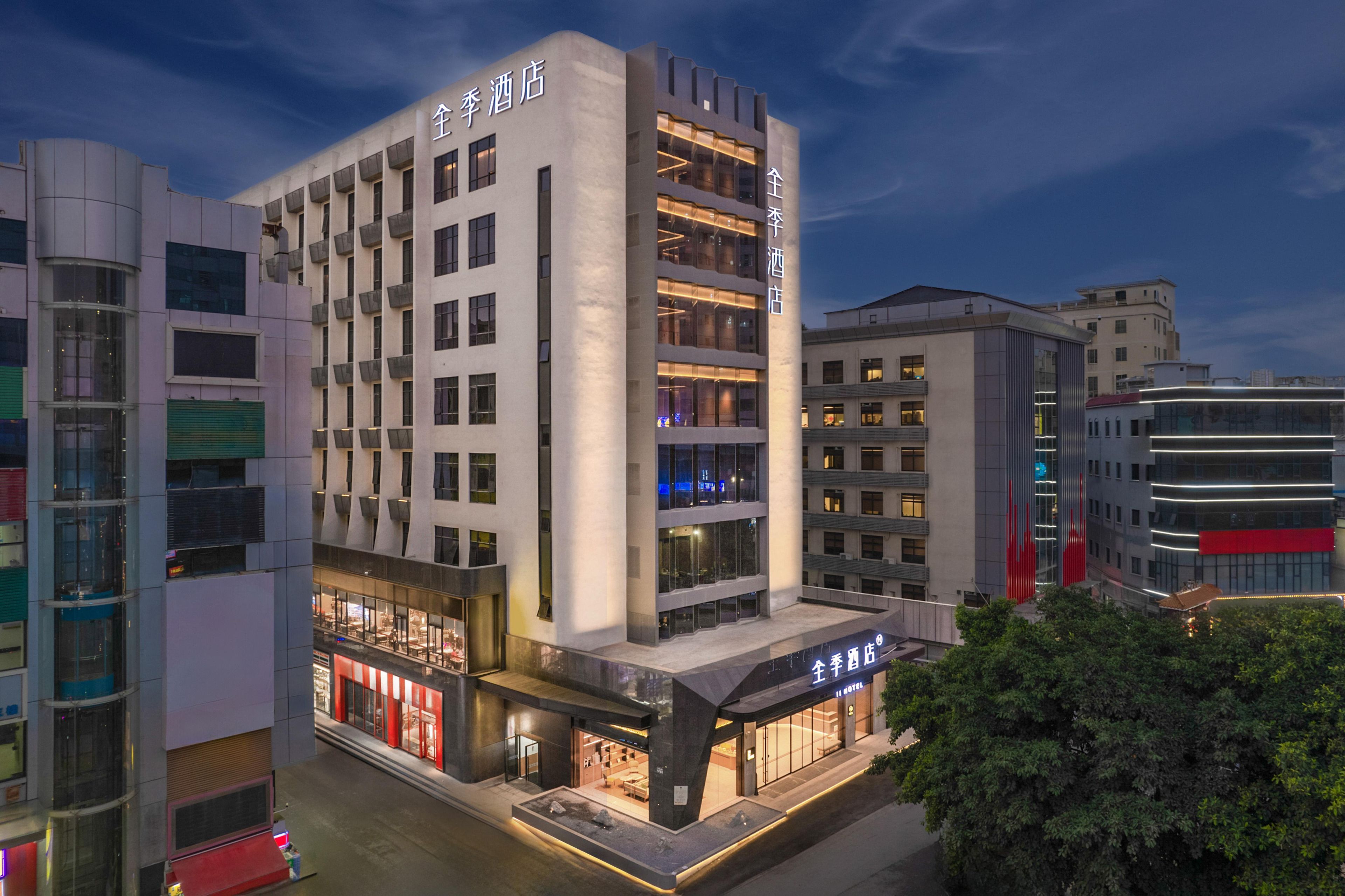A modern hotel with multiple floors, large windows, and a prominent entrance.