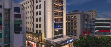 A modern hotel with multiple floors, large windows, and a prominent entrance.