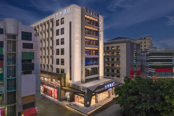 Un hotel moderno con varios pisos, amplias ventanas y una entrada destacada.