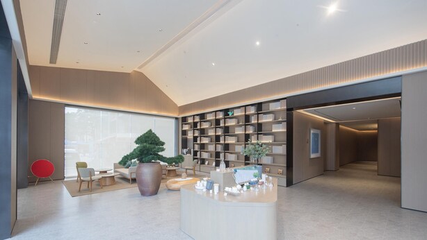 A modern hotel lobby with a reception desk, seating area, and a large potted plant. - Ji Hotel Guangzhou Baiyun Station Sanyuanli Avenue (Guangzhou)
