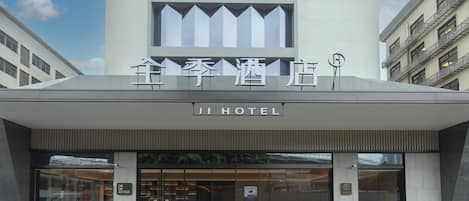 The exterior of Ji Hotel with a modern design, large glass windows, and a sign indicating a KETTING restaurant inside.