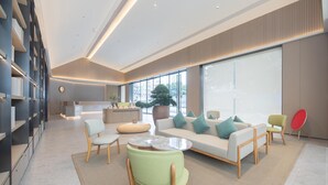 A modern interior with a seating area, a kitchen, and large windows. - Ji Hotel Guangzhou Baiyun Station Sanyuanli Avenue (Guangzhou)