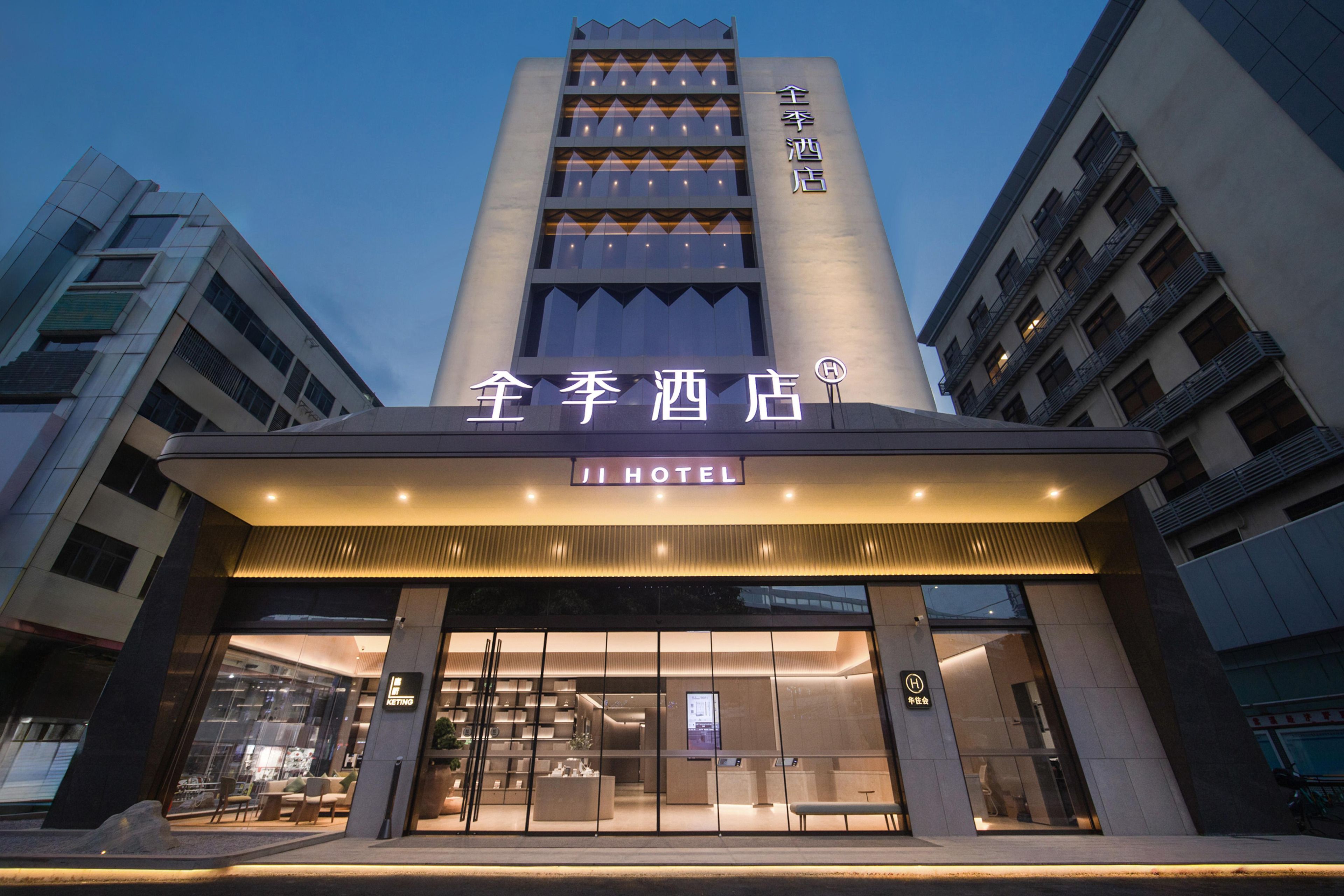 Exterior del Ji Hotel con fachada moderna, amplios ventanales y una entrada destacada.