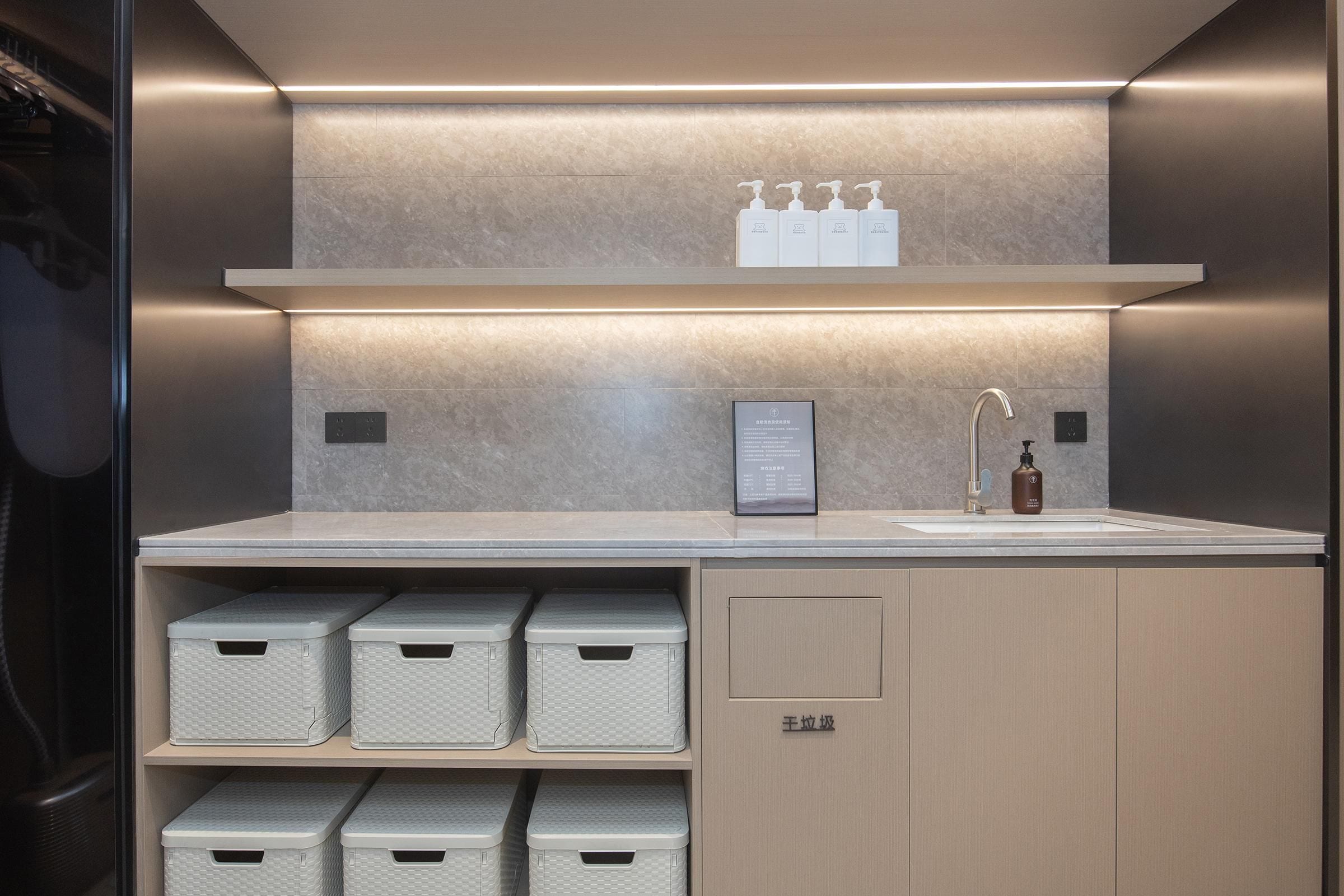 A modern bathroom with a built-in sink, storage cabinets, and a shelf with toiletries.