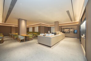 A modern hotel lobby with a central island counter, seating area, and a kitchenette. - Ji Hotel Guangzhou Baiyun Station Sanyuanli Avenue (Guangzhou)