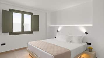 Quarto moderno com uma cama grande, uma janela com as persianas abertas e um candeeiro fixado na parede.