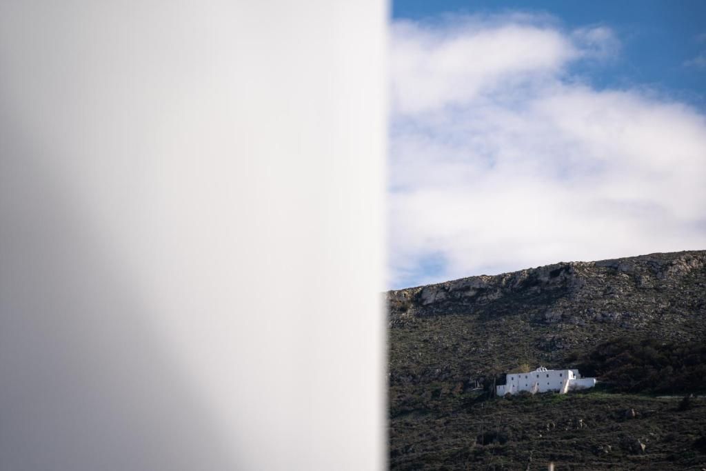 Um edifício branco numa encosta, sob um céu claro.