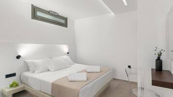 Un dormitorio moderno con cama, mesita de noche y una planta pequeña.