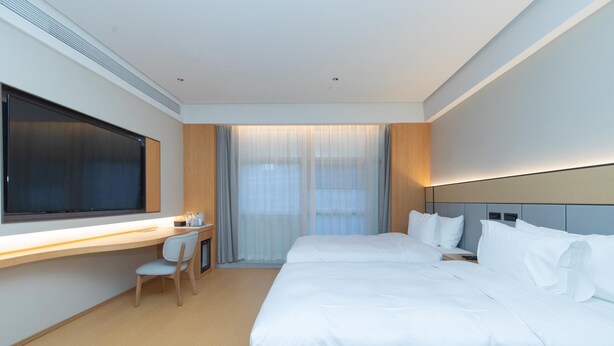 A modern hotel room with a large bed, a desk with a chair, and a large window with curtains. - Ji Guangzhou Beijing Road Tuanyida Square (Guangzhou)