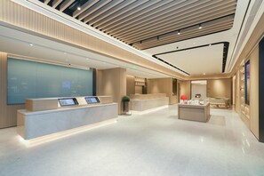 A modern hotel lobby with a reception desk, a seating area, and a large glass wall. - Ji Guangzhou Beijing Road Tuanyida Square (Guangzhou)
