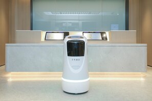A modern hotel reception desk with a digital kiosk and a standalone device on the counter. - Ji Guangzhou Beijing Road Tuanyida Square (Guangzhou)