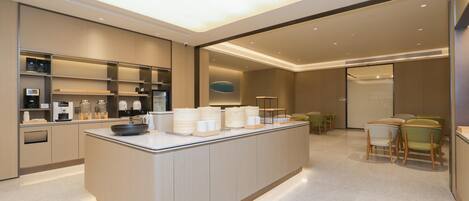 A modern kitchen with a central island, built-in appliances, and a seating area with chairs.