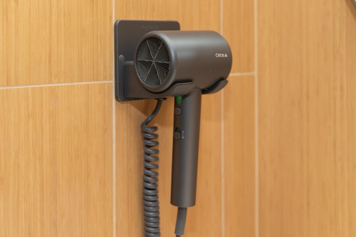 A hair dryer mounted on a wooden wall.