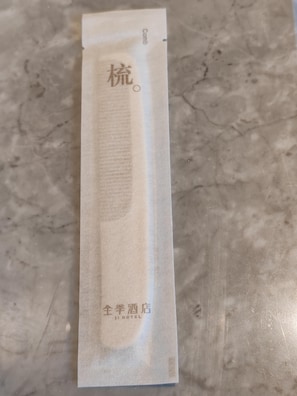 Un paquete con texto en un idioma extranjero y la inscripción "JI HOTEL" en la parte inferior.