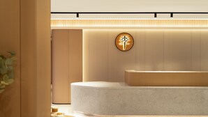 A modern reception area with a circular sign, a reception desk, and a plant. - Ji Guangzhou Liwan TCL Yunfeng Technology Park (Guangzhou)