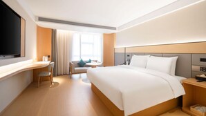 A modern hotel room with a large bed, a desk, a chair, and a TV. - Ji Guangzhou Liwan TCL Yunfeng Technology Park (Guangzhou)