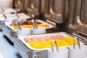 A buffet with various food items in trays, including eggs and corn. - Ji Guangzhou Liwan TCL Yunfeng Technology Park (Guangzhou)