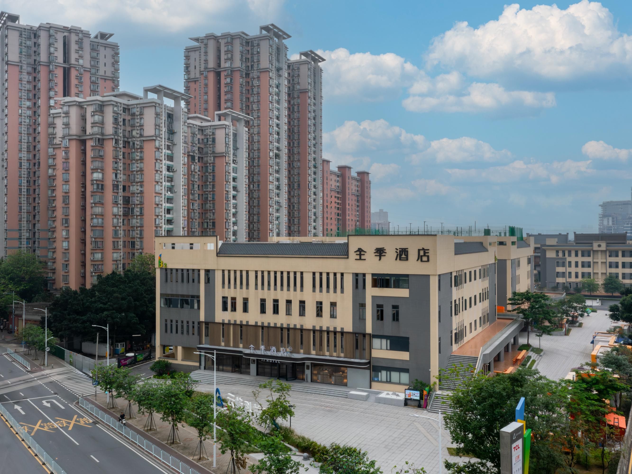 A hotel with a modern facade, located in a high-rise residential area.