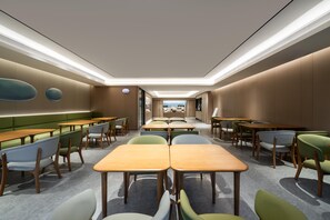 A modern dining area with multiple tables and chairs, a view to the outside, and a ceiling with recessed lighting. - Ji Guangzhou Liwan TCL Yunfeng Technology Park (Guangzhou)