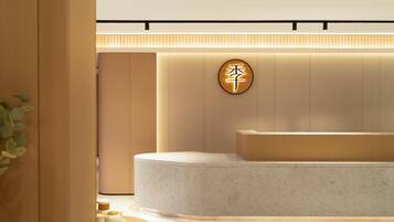 A modern reception area with a circular sign, a reception desk, and a plant.