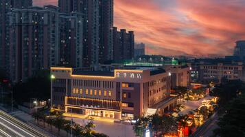 A hotel with a modern facade, multiple floors, and a well-lit entrance.