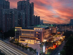 A hotel with a modern facade, multiple floors, and a well-lit entrance. - Ji Guangzhou Liwan TCL Yunfeng Technology Park (Guangzhou)