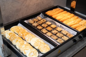 Een buffet met diverse gebakken producten, zoals broodjes en gebak.