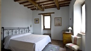 Une chambre à coucher avec un lit, une chaise, un bureau et une fenêtre.