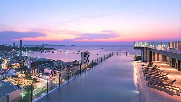 Un hôtel situé au bord de l’eau, doté d’un long balcon offrant une vue sur la mer, ainsi que sur la ville, et présentant une architecture moderne.