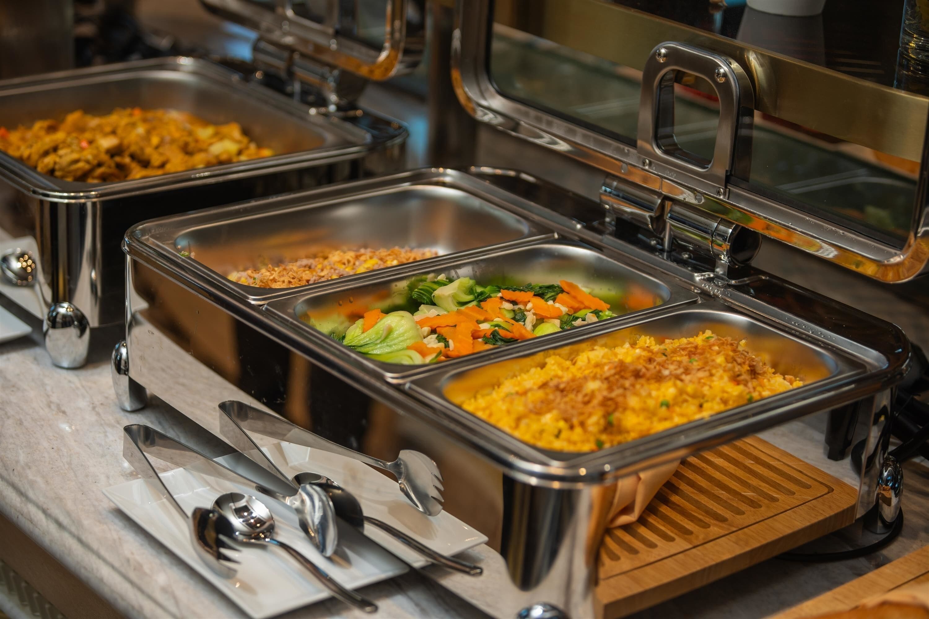 A buffet with various dishes including rice, vegetables, and meat.
