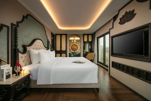 A hotel room with a large bed, a television, a nightstand with a wine glass, and a decorative wall. - Proverb Hotel Hanoi (Hanoi)