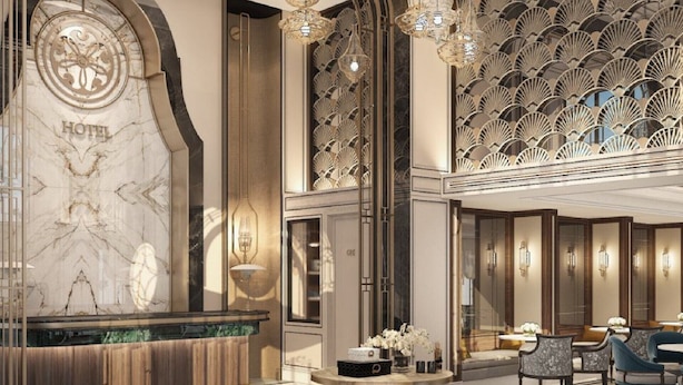A luxurious hotel lobby with a marble reception desk, elegant chandeliers, and a patterned wall design. - Proverb Hotel Hanoi (Hanoi)