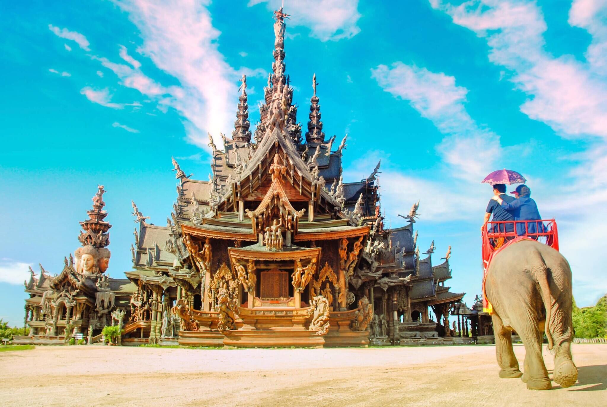 A traditional temple with intricate architecture and a person riding an elephant.