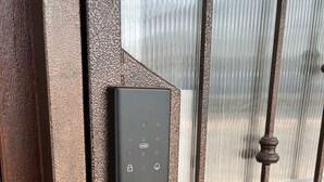 A security keypad attached to a metal gate with vertical bars. - Baan saen saran residence (แขวงคลองชักพระ เขตตลิ่งชัน)