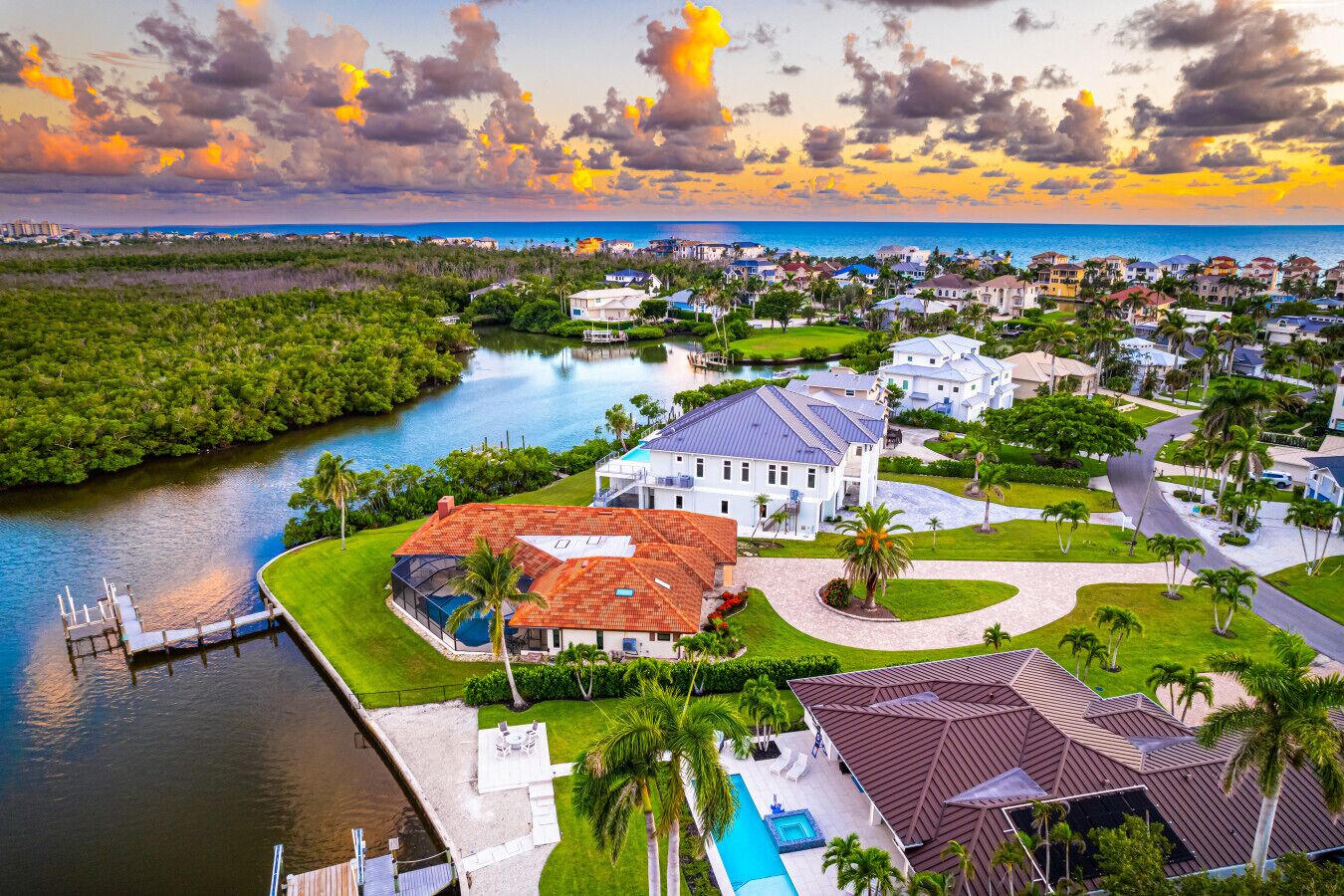 Zona residencial con casas, piscina y muelle junto al agua.