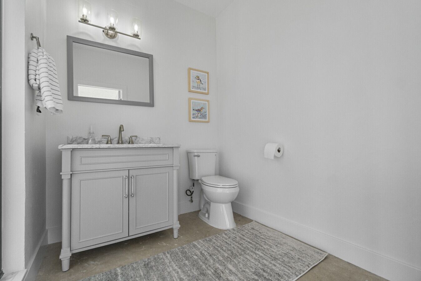 Ein Badezimmer mit weißem Waschtisch, Toilette und Duschbereich.