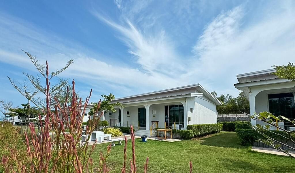 A modern two-story house with a well-maintained lawn and a patio area.