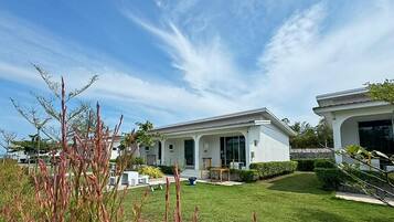 A modern two-story house with a well-maintained lawn and a patio area.