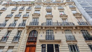 A multi-story building with ornate balconies, large windows, and a prominent entrance. - Modern Apartment - 2P - Parc Monceau (Paris)