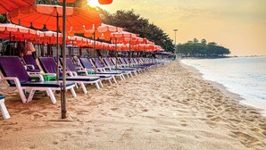 A beach with rows of sun loungers and orange umbrellas. - Excellent Location - Condo Infinity Pool Pattaya (Pattaya)