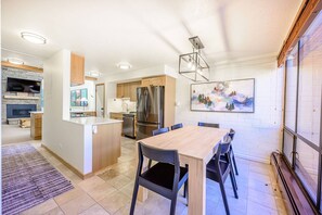 Una cocina moderna con una isla central, armarios de madera y un refrigerador de acero inoxidable.